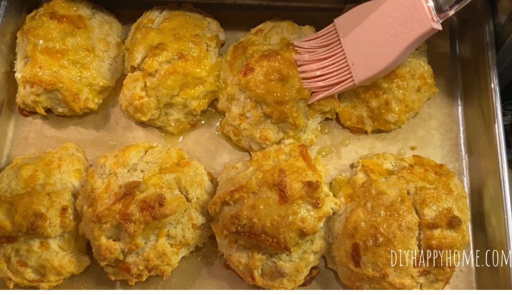 Look at those deliciously fresh baked biscuits getting brushed with honey butter! ​